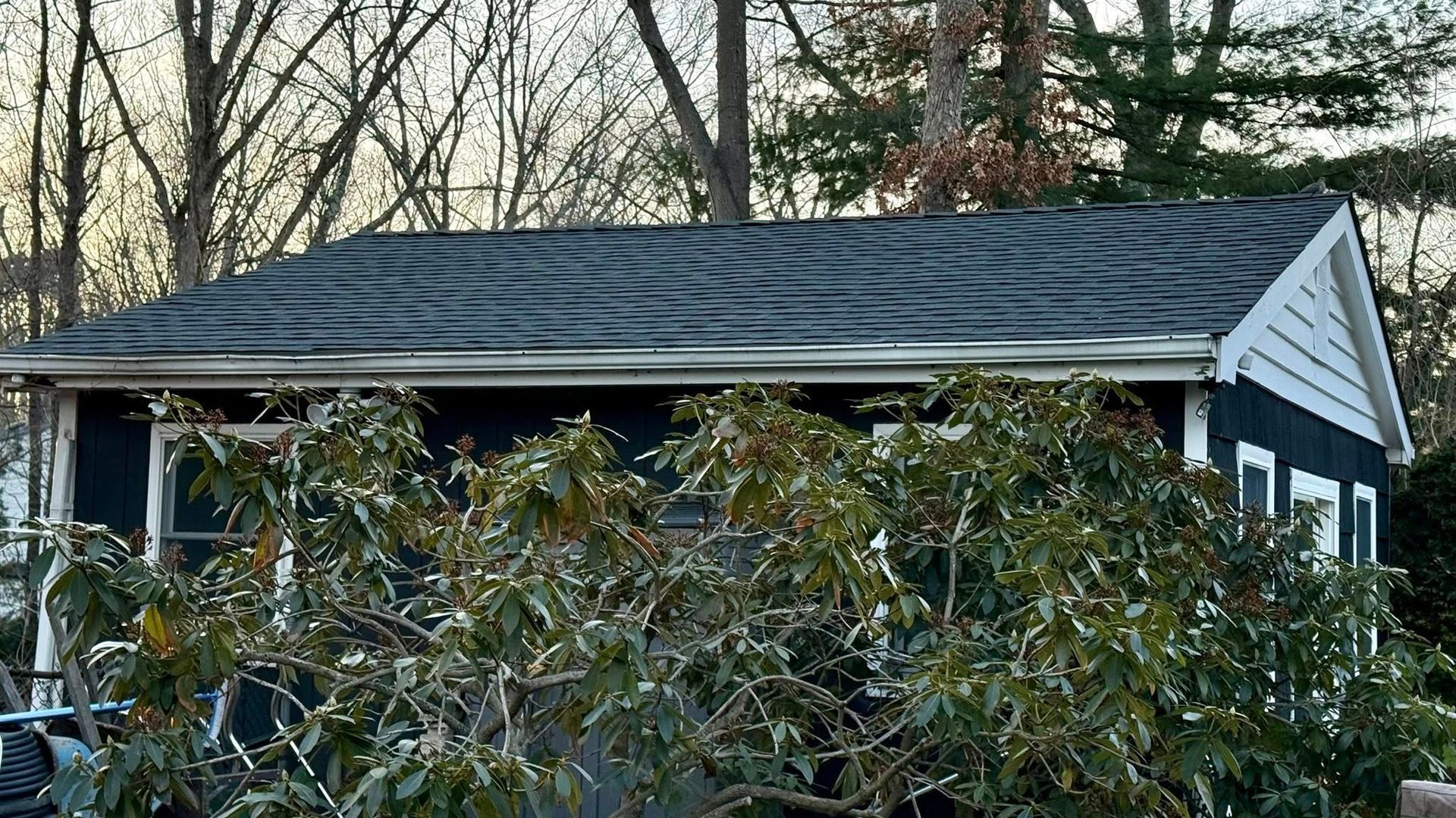Back deck with white railings and a chair on gray boards
