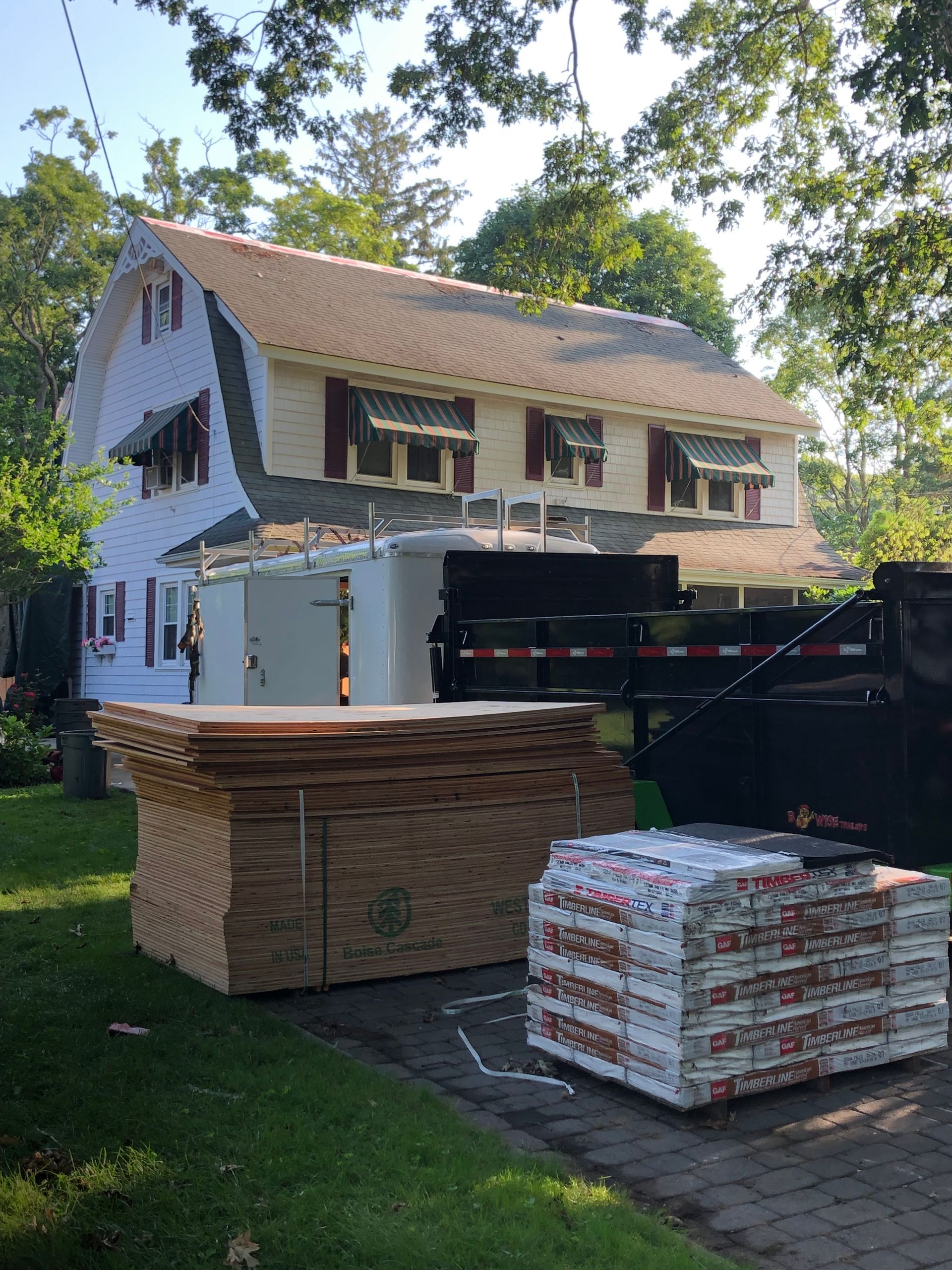 Materials stacked near a Dutch Colonial house for a roof replacement